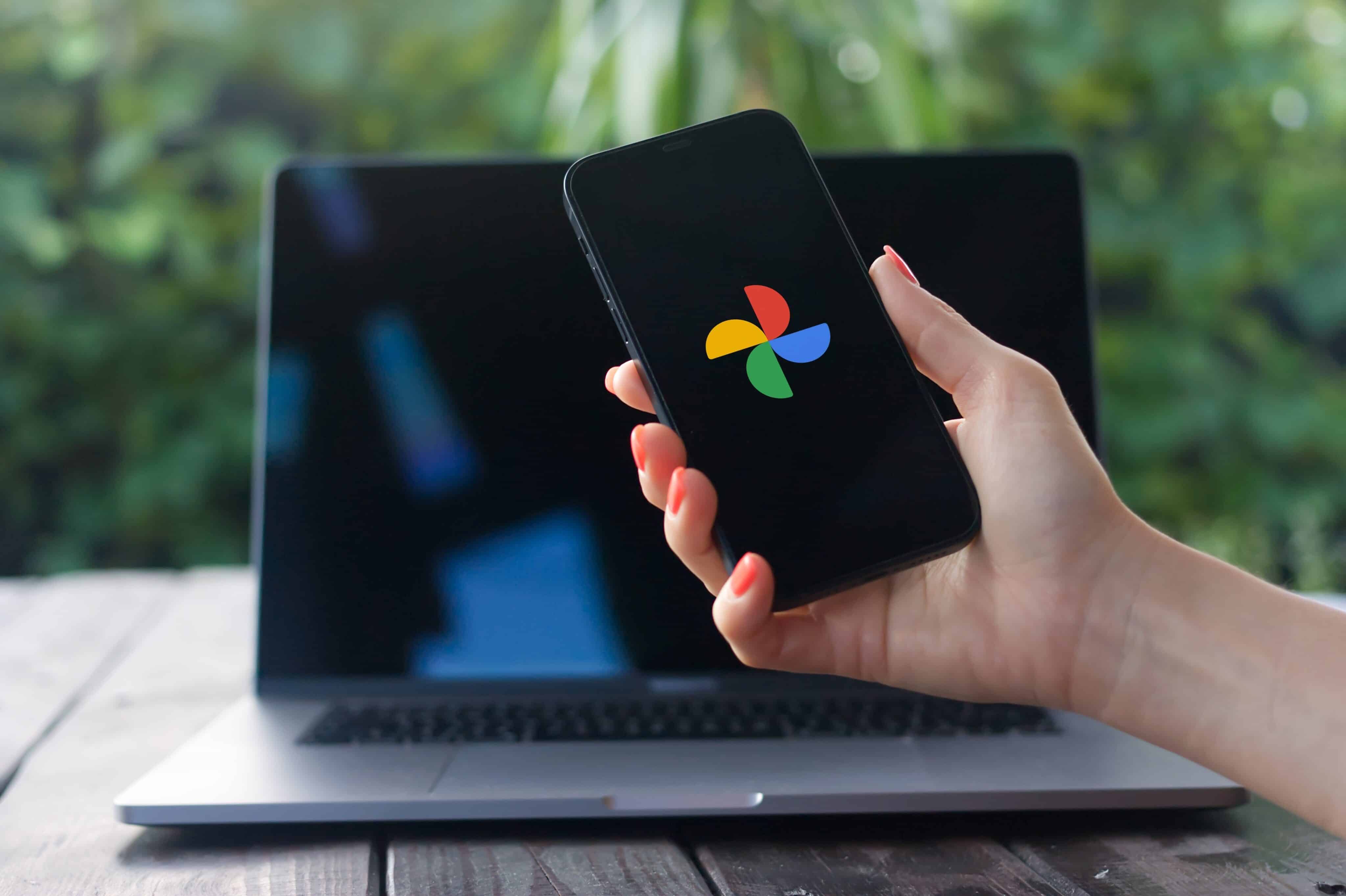 Logotipo de Google Photos en un iPhone frente a una MacBook