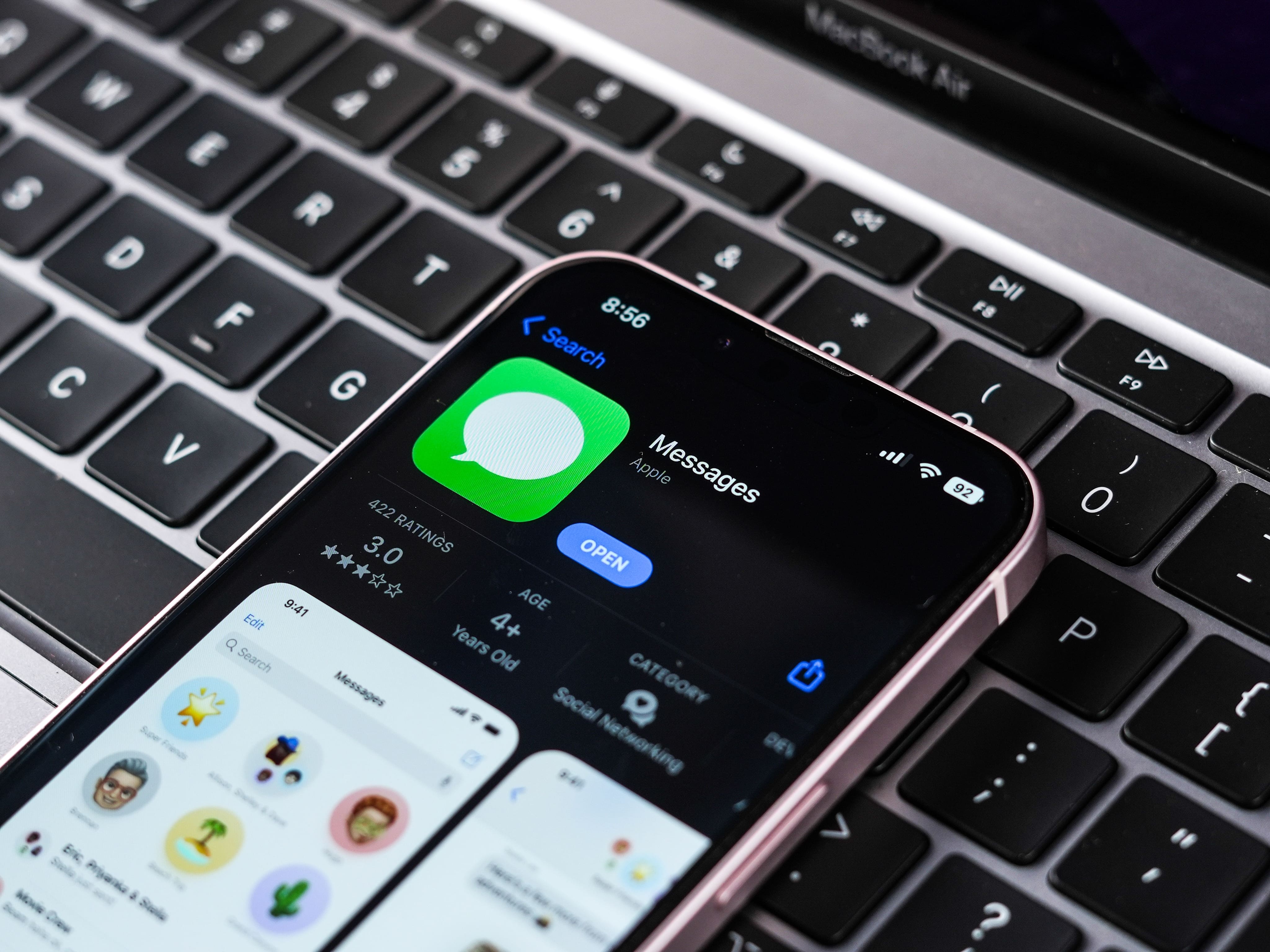 Aplicación de mensajes en la App Store en un iPhone, que se encuentra encima del teclado de una Mac