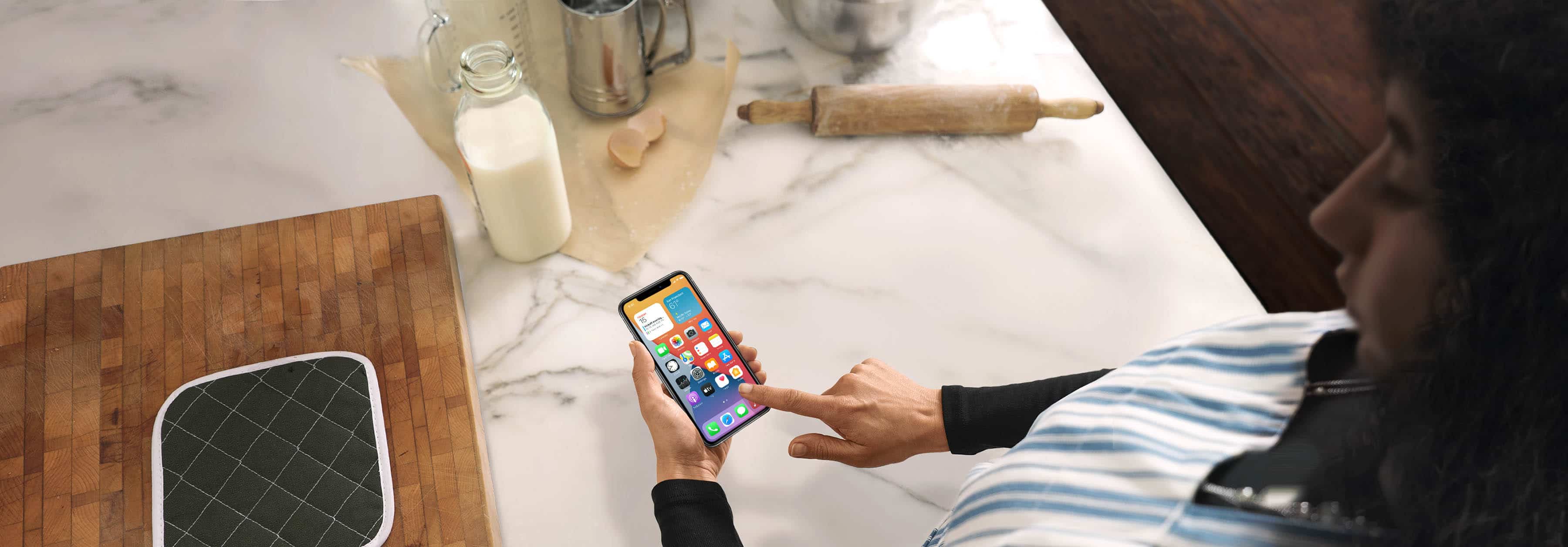 Mujer usando un iPhone en la cocina