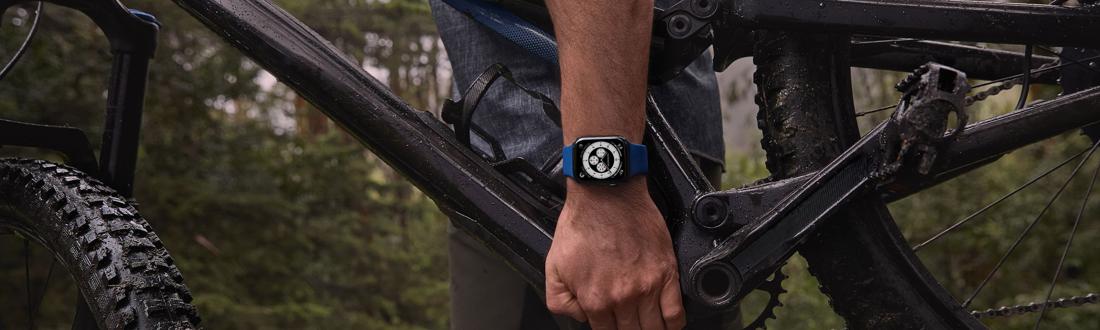 Hombre sujetando una bicicleta con Apple Watch en la muñeca
