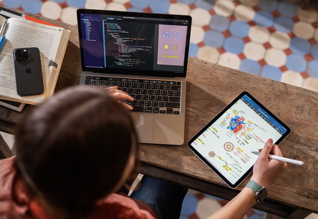 Mujer usando un iPhone, una MacBook Pro y un iPad