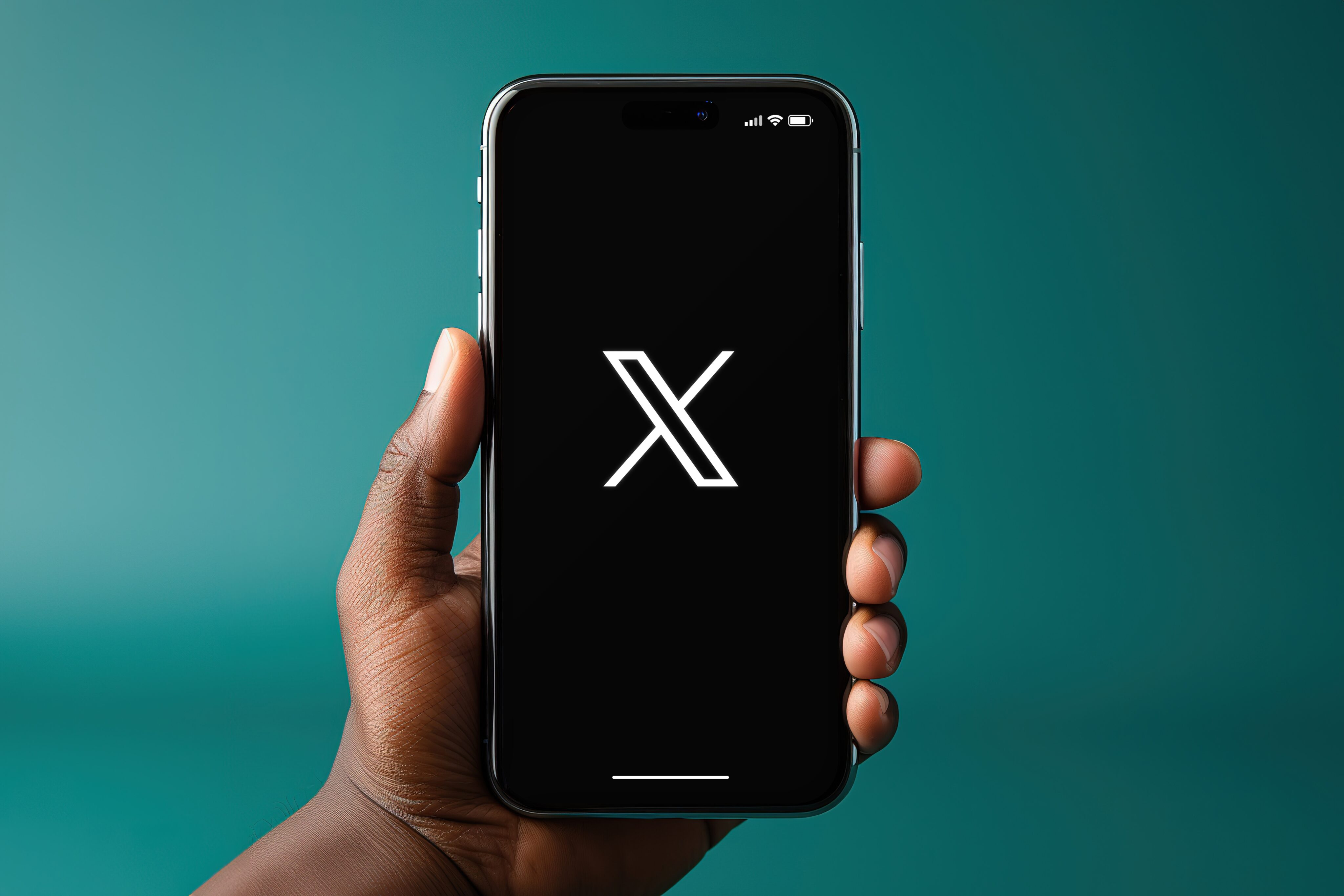 Persona sosteniendo un iPhone X con el logo de la red social X.