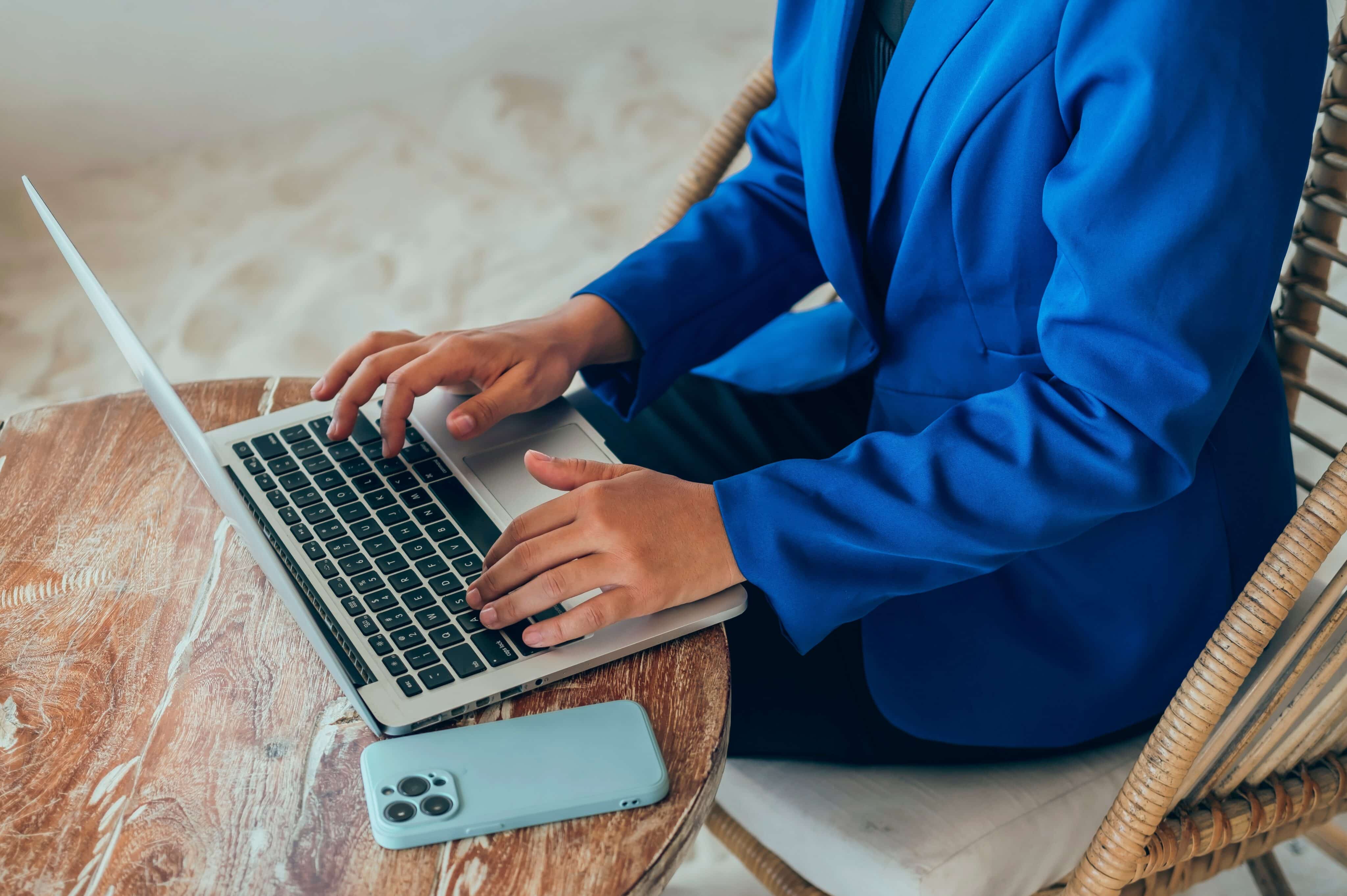 Mujer usando una Mac con un iPhone a su lado
