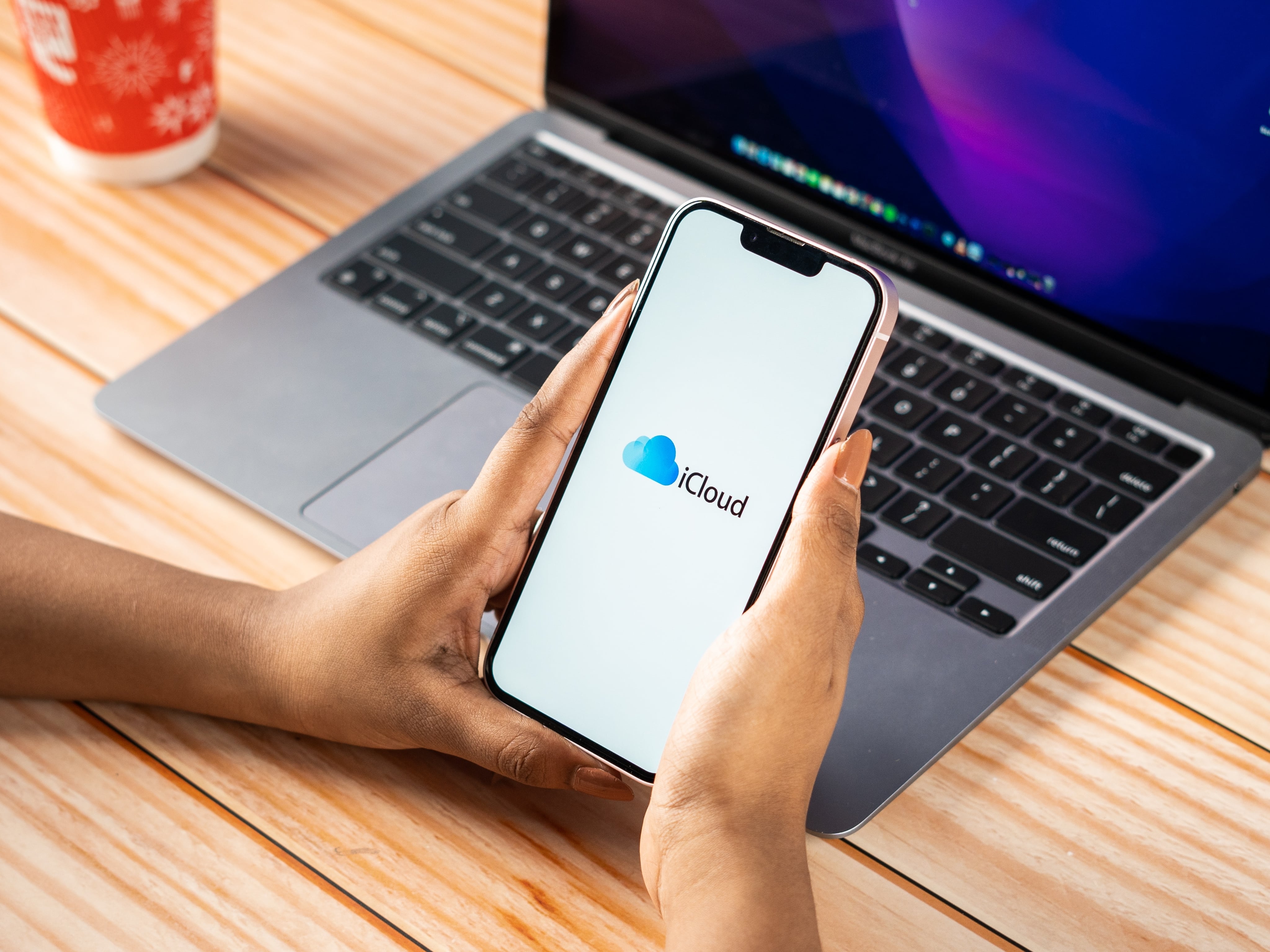 iPhone con el logo de iCloud y una Mac de fondo