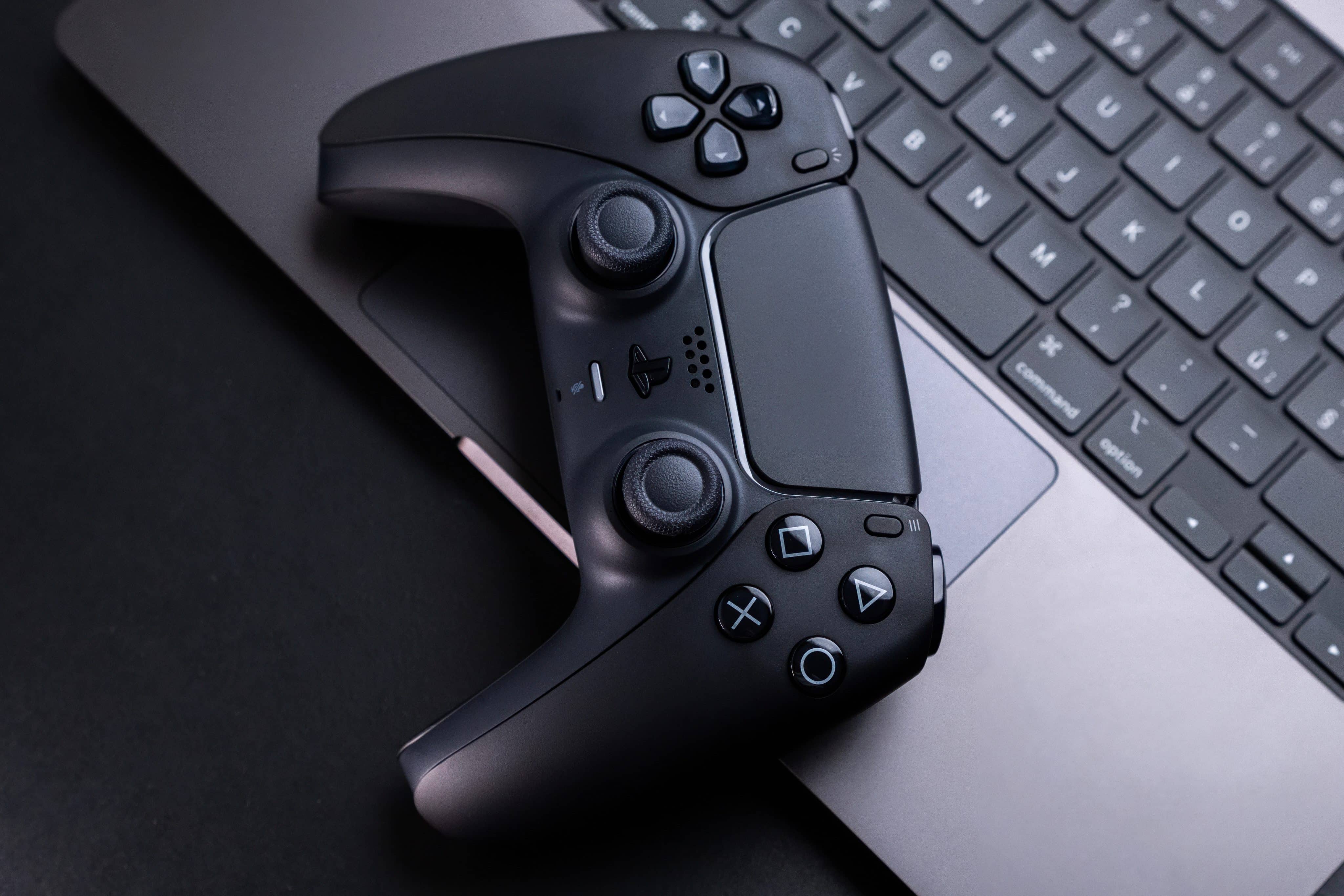 Controlador de videojuegos junto a una MacBook Pro